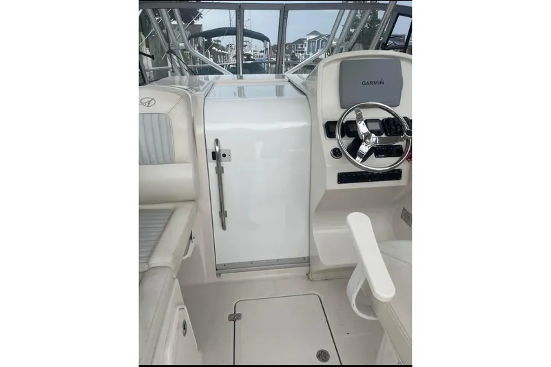Slide: The Image of 2011 Sailfish 2660 WAC boat cockpit with steering wheel and Garmin display. - 13