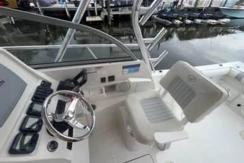 Slide: The Image of 2011 Sailfish 2660 WAC boat cockpit with steering wheel and seating at marina. - 2