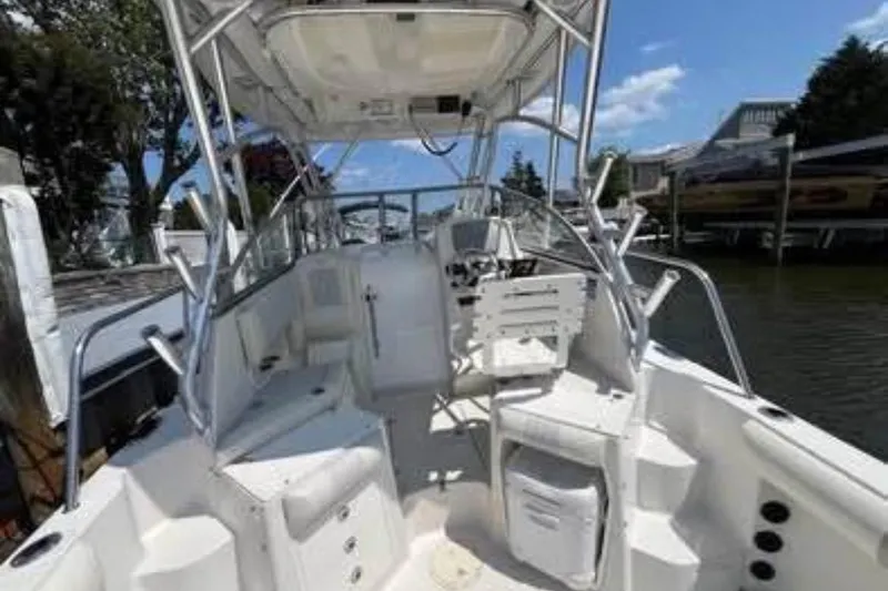 Slide: The Image of 2011 Sailfish 2660 WAC boat interior with helm and seating, docked by the water. - 3