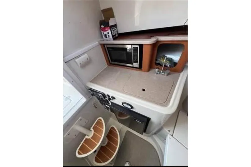 Slide: The Image of Compact kitchen area in 2011 Sailfish 2660 WAC boat with microwave and sink. - 5