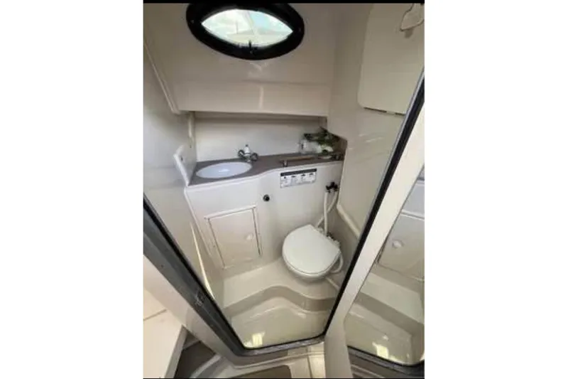 Slide: The Image of Compact bathroom in 2011 Sailfish 2660 WAC boat, featuring sink and toilet. - 8