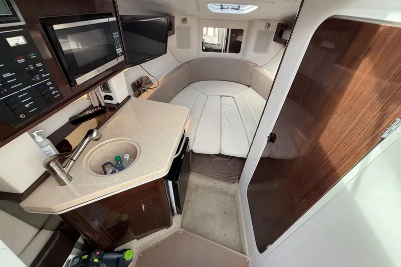 Slide: The Image of Interior of 2015 Sea Ray 260 Sundancer boat with kitchenette and seating area. - 12