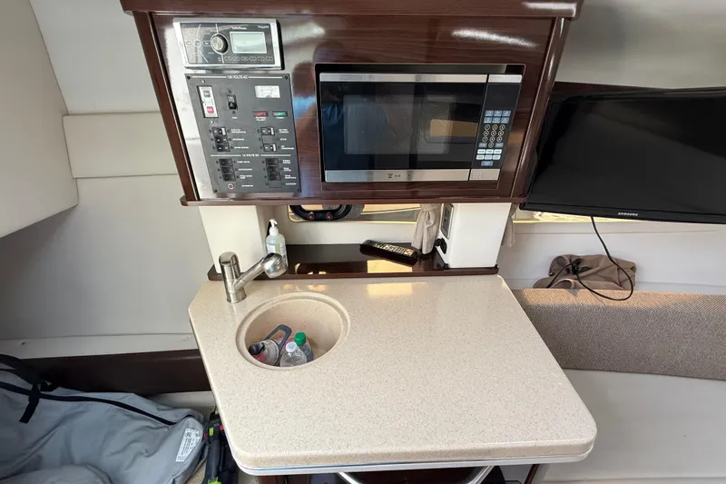Slide: The Image of Compact kitchen area in a 2015 Sea Ray 260 Sundancer with microwave and sink. - 13
