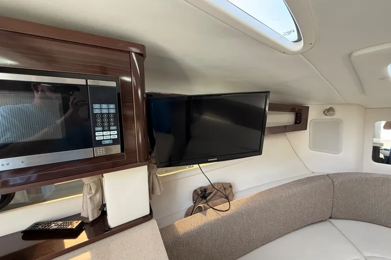 Slide: The Image of Interior of 2015 Sea Ray 260 Sundancer with microwave, TV, and seating area. - 16