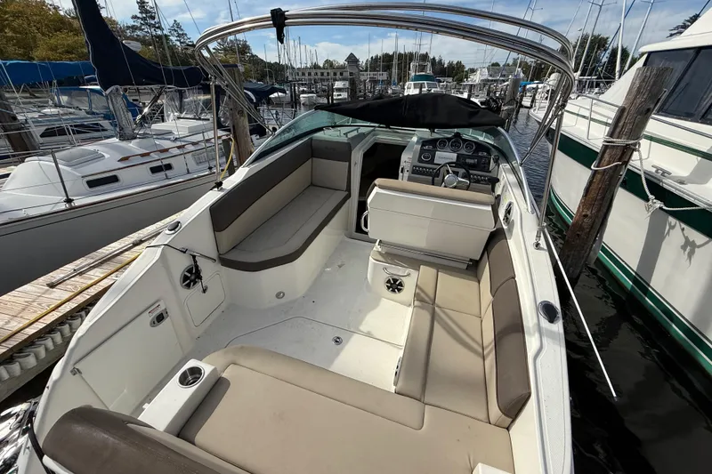 Slide: The Image of 2015 Sea Ray 260 Sundancer boat interior with seating and helm, docked at marina. - 3