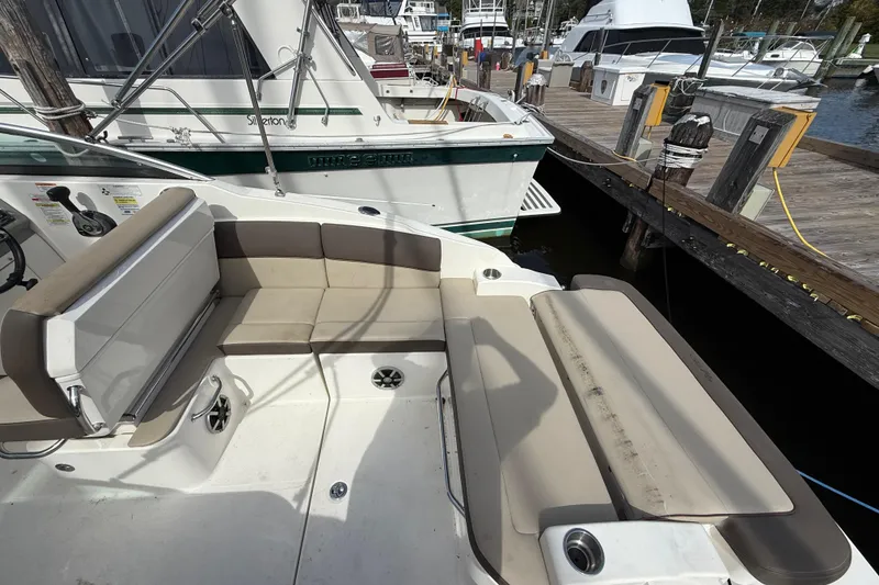 Slide: The Image of 2015 Sea Ray 260 Sundancer boat interior with beige seating at marina dock. - 6