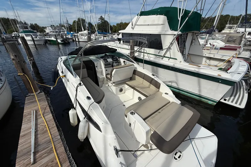 Slide: The Image of 2015 Sea Ray 260 Sundancer docked at marina, surrounded by other boats. - 7