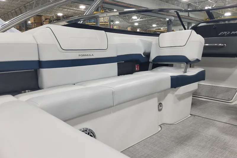 Slide: The Image of 2026 Formula 270 Bowrider interior with white and blue seating in a showroom. - 10
