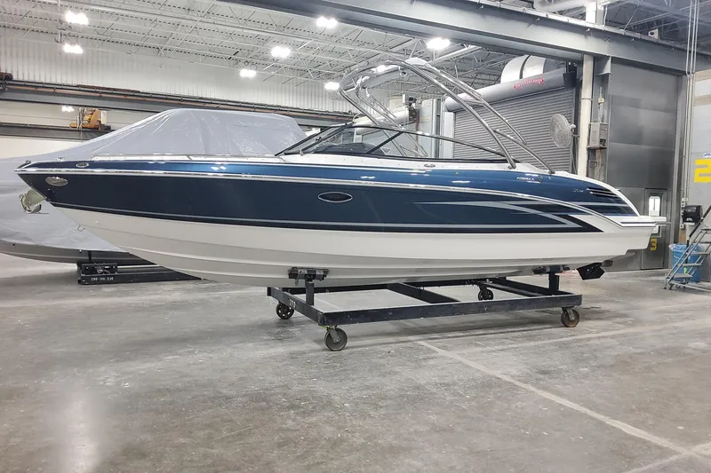 Slide: The Image of 2026 Formula 270 Bowrider boat in a warehouse, showcasing sleek design and modern features. - 2