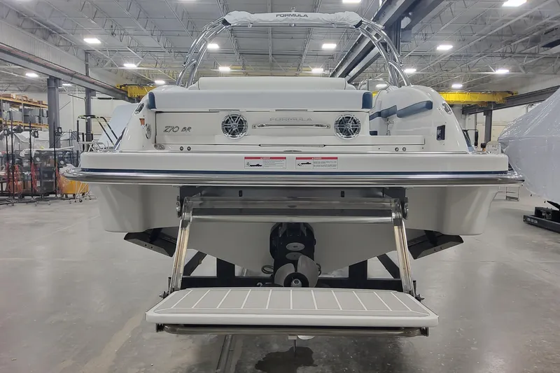 Slide: The Image of 2026 Formula 270 Bowrider boat in a warehouse, rear view with swim platform. - 4