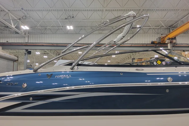 Slide: The Image of 2026 Formula 270 Bowrider boat in a warehouse, showcasing sleek blue and white design. - 6