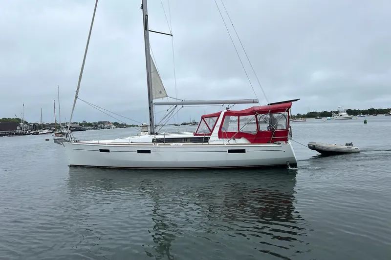 The Image of 2013 Beneteau Oceanis 45 sailboat with red canopy, anchored in calm waters. - 0