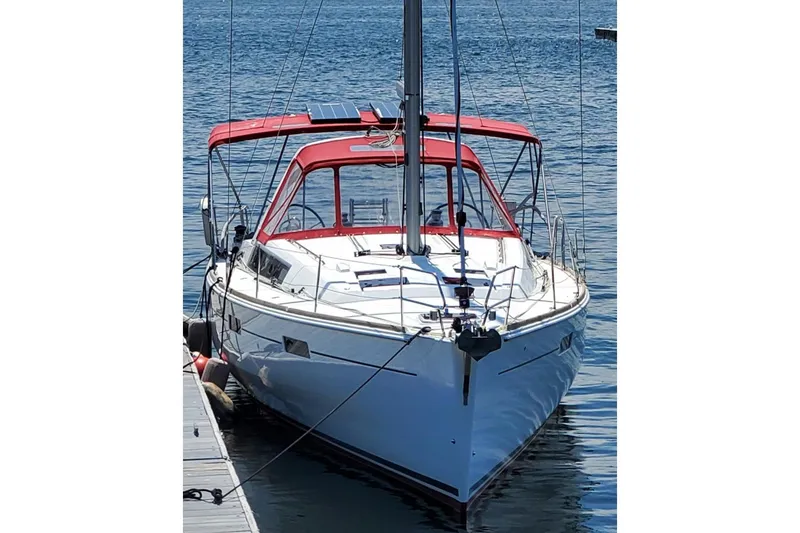Slide: The Image of 2013 Beneteau Oceanis 45 sailboat docked with red canopy, calm water background. - 2