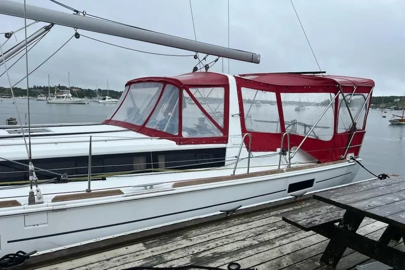 Slide: The Image of 2013 Beneteau Oceanis 45 sailboat with red canopy docked in a marina. - 3