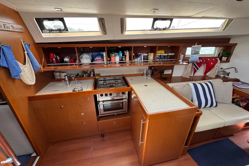 Slide: The Image of Interior of 2013 Beneteau Oceanis 45 yacht, featuring a well-equipped kitchen and cozy seating area. - 36