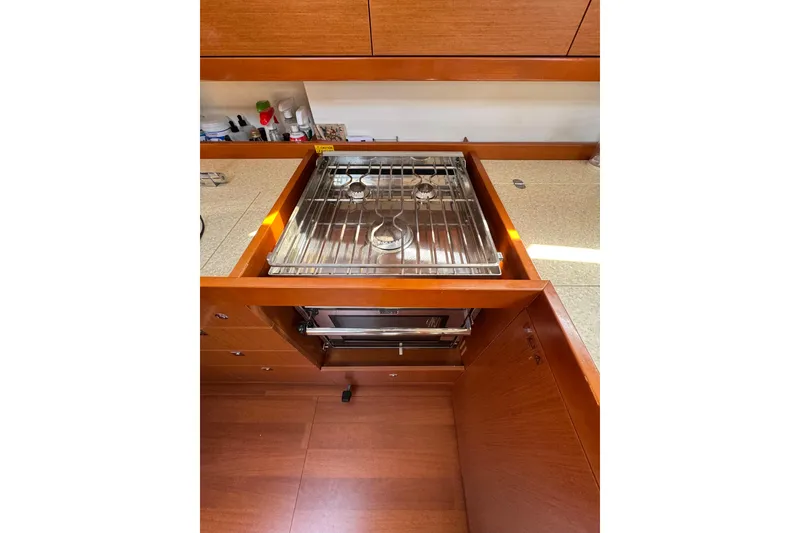 Slide: The Image of Galley kitchen in 2013 Beneteau Oceanis 45 yacht with stove and wooden cabinetry. - 42