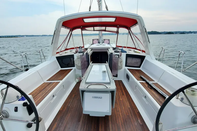 Slide: The Image of 2013 Beneteau Oceanis 45 sailboat cockpit with red canopy, wooden deck, and dual steering wheels. - 6