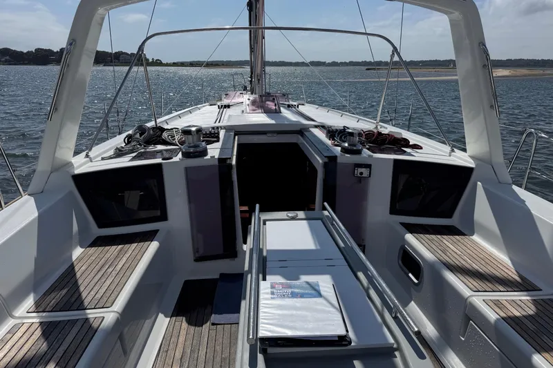 Slide: The Image of 2013 Beneteau Oceanis 45 sailboat cockpit with open hatch, docked on calm waters. - 8