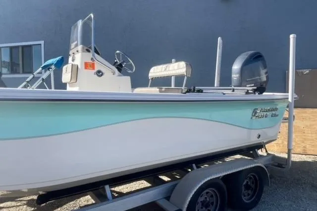 Slide: The Image of 2021 Carolina Skiff 21 LS boat on trailer, side view, light blue and white design. - 2