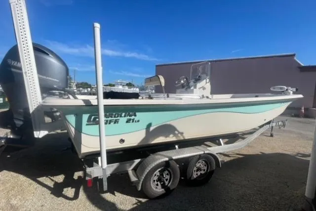 Slide: The Image of 2021 Carolina Skiff 21 LS boat on trailer, parked outdoors under clear blue sky. - 3