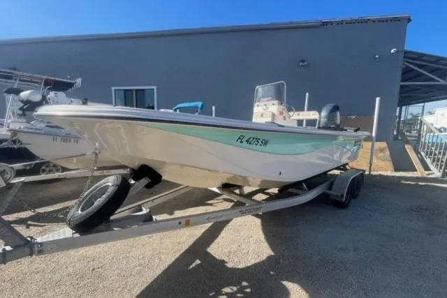 Slide: The Image of 2021 Carolina Skiff 21 LS boat on trailer, parked outdoors under clear blue sky. - 4