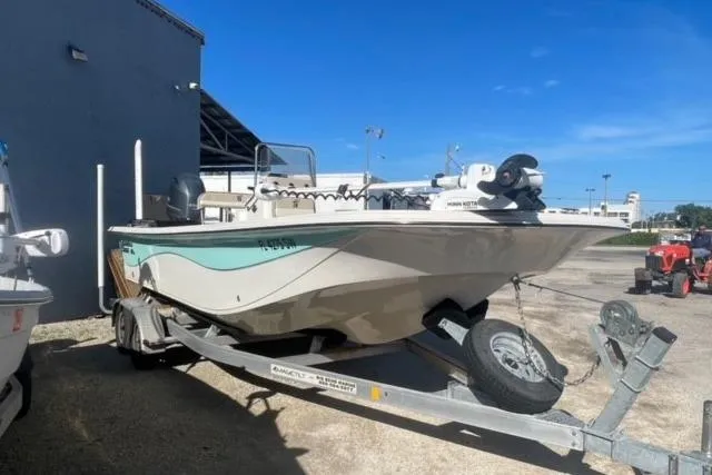 Slide: The Image of 2021 Carolina Skiff 21 LS boat on trailer, parked outdoors under clear blue sky. - 6