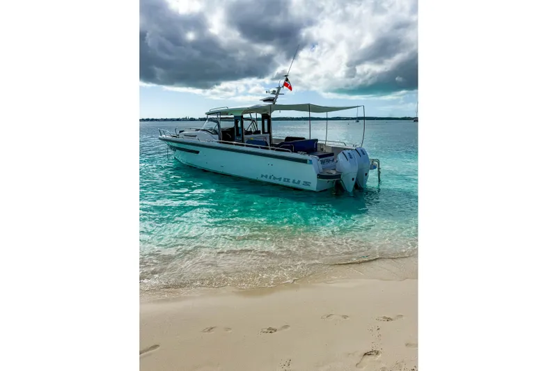 Slide: The Image of Nimbus T11 2022 boat anchored on turquoise water near sandy beach under cloudy sky. - 5