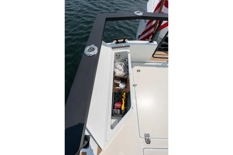 Slide: The Image of Storage compartment on 2026 Targa 32 GT boat, open with various items inside. - 11