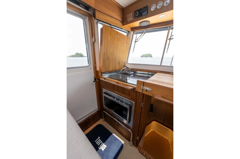 Slide: The Image of Interior of 2026 Targa 32 GT boat with wooden cabinetry and compact kitchen area. - 30