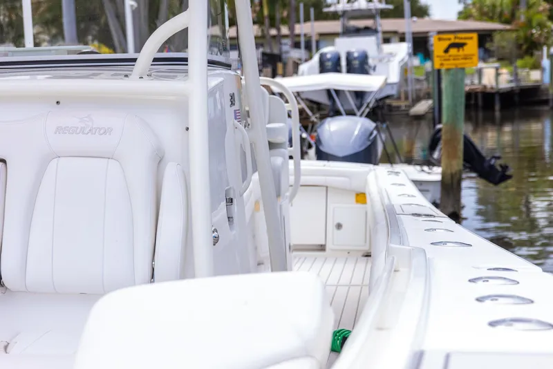 Slide: The Image of 2019 Regulator 34 boat docked in marina, featuring sleek white design and spacious deck. - 10
