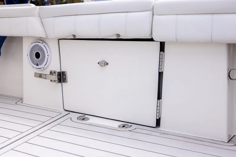 Slide: The Image of 2019 Regulator 34 boat storage compartment with speaker and white cushioned seating. - 20