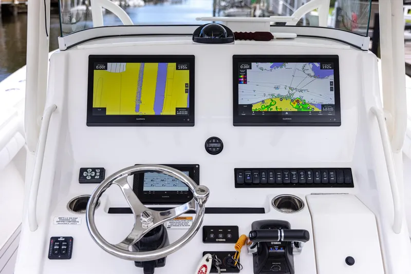 Slide: The Image of 2019 Regulator 34 boat dashboard with dual navigation screens and steering wheel. - 21