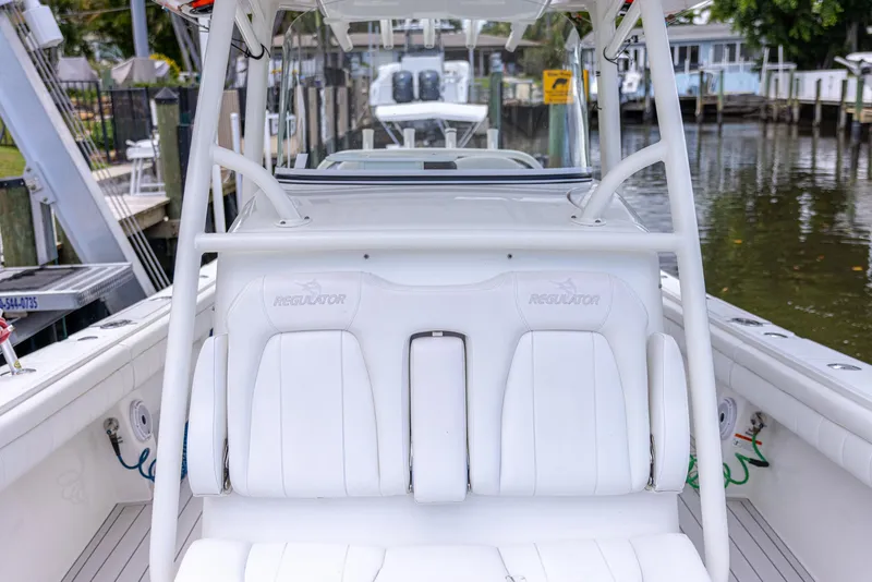 Slide: The Image of 2019 Regulator 34 boat interior with white seating, docked in a marina. - 8