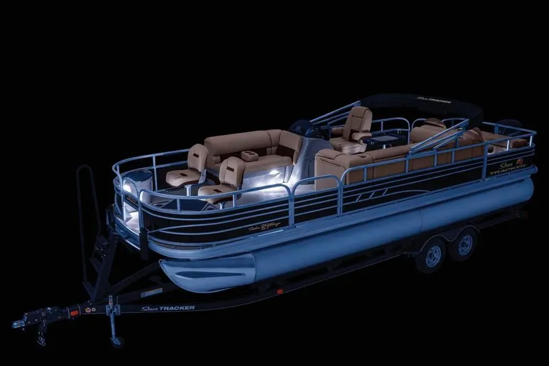 Slide: The Image of 2021 Sun Tracker Fishin' Barge 24 DLX pontoon boat with illuminated interior on trailer. - 4