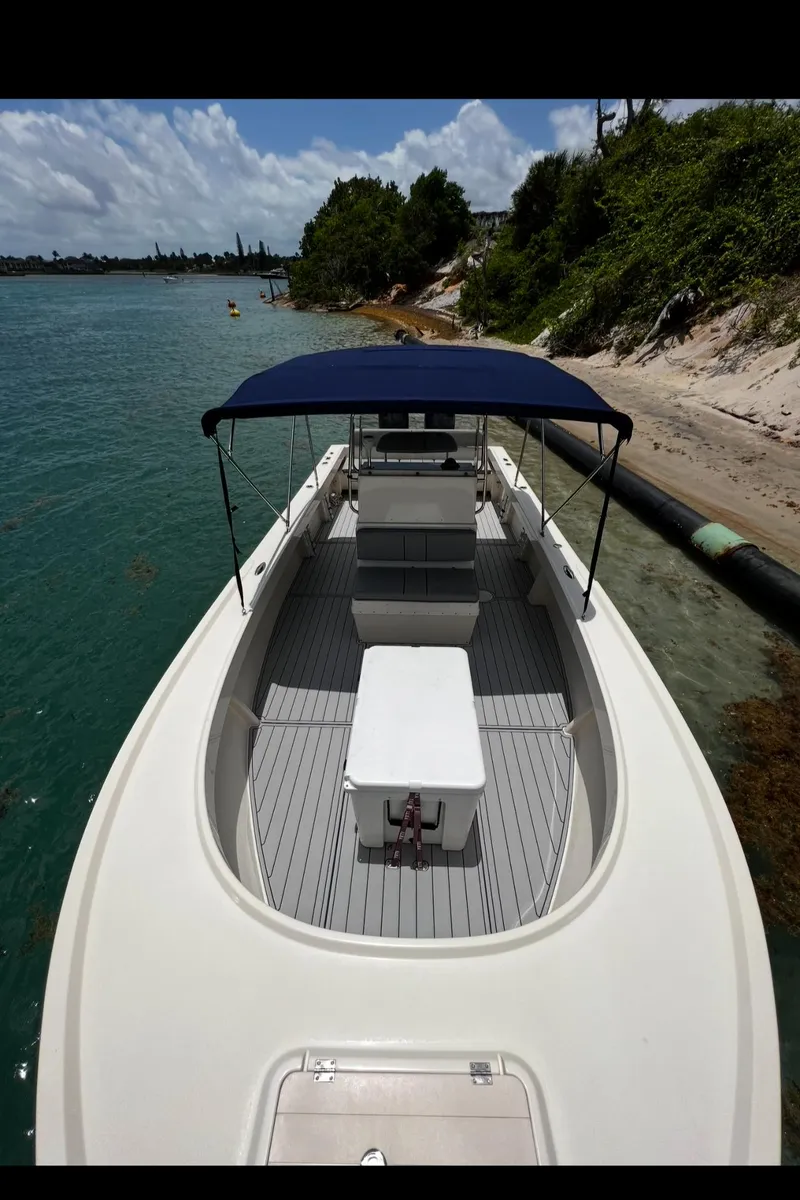 Slide: The Image of 2002 Parker 2500 Special Edition boat with canopy, docked by a scenic shoreline. - 11