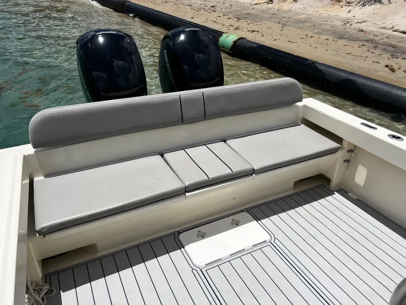 Slide: The Image of 2002 Parker 2500 Special Edition boat with cushioned seating and twin engines near sandy shore. - 6