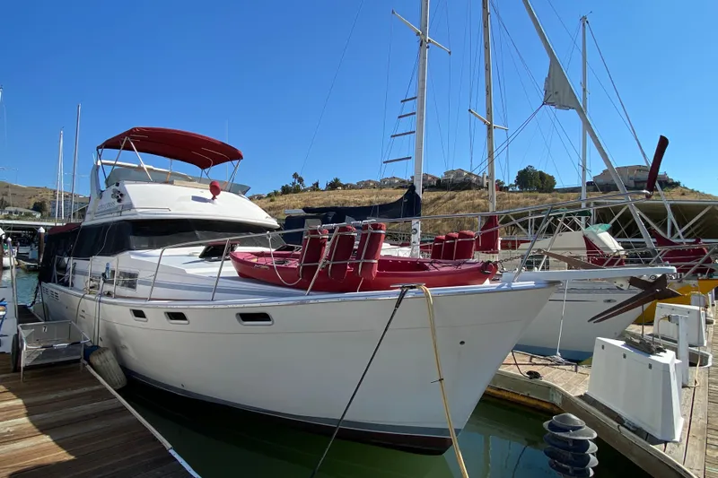 Slide: The Image of 1989 Bayliner 3888 Motoryacht docked at marina under clear blue sky. - 1