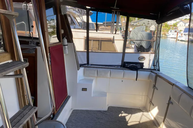 Slide: The Image of 1989 Bayliner 3888 Motoryacht interior with marina view, featuring seating and ladder. - 10