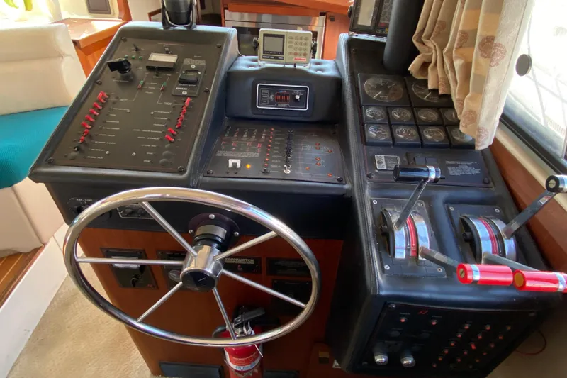 Slide: The Image of 1989 Bayliner 3888 Motoryacht helm with steering wheel, control panels, and throttle levers. - 12