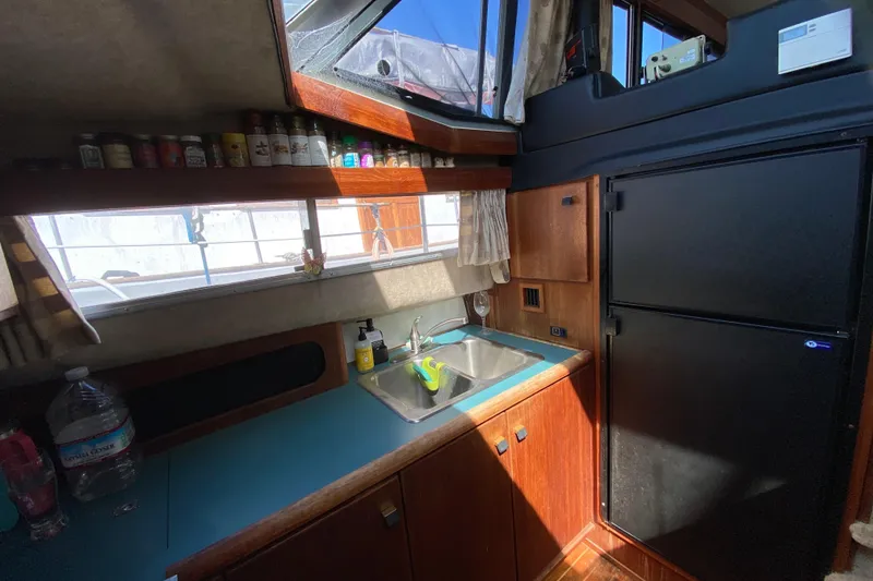 Slide: The Image of 1989 Bayliner 3888 Motoryacht kitchen with sink, fridge, and spice shelf. - 15