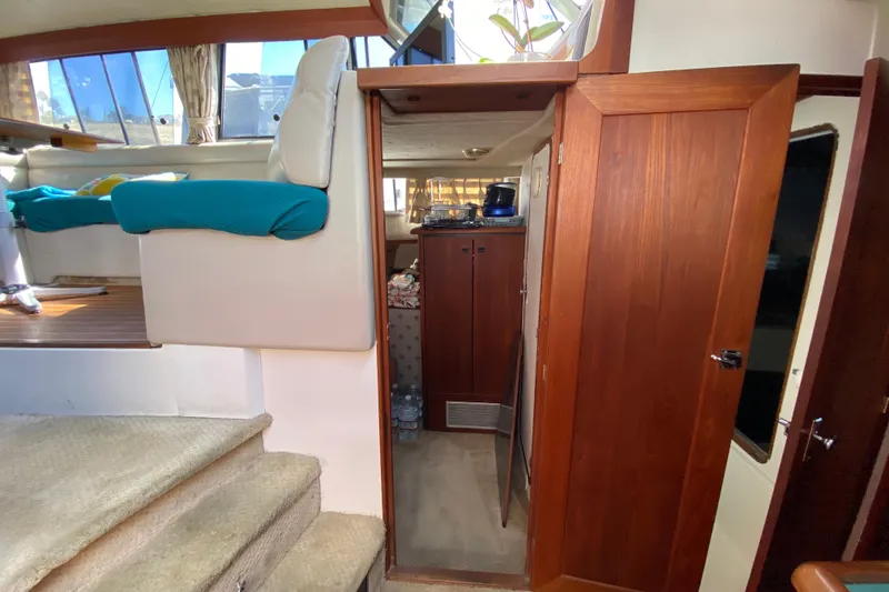 Slide: The Image of 1989 Bayliner 3888 Motoryacht interior with wooden cabinetry and seating area. - 16