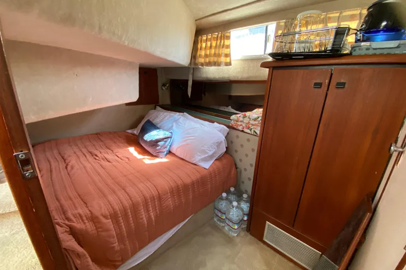 Slide: The Image of Cozy bedroom in 1989 Bayliner 3888 Motoryacht with bed, pillows, and wooden cabinet. - 17