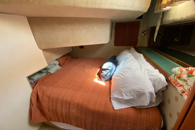 Slide: The Image of Cozy bedroom interior of 1989 Bayliner 3888 Motoryacht with orange bedding and pillows. - 18