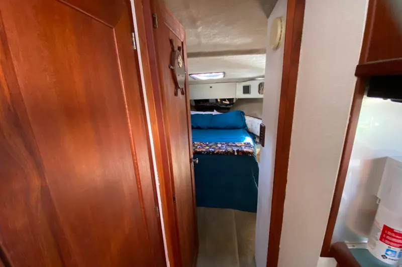 Slide: The Image of 1989 Bayliner 3888 Motoryacht interior with cozy bedroom and wooden accents. - 19