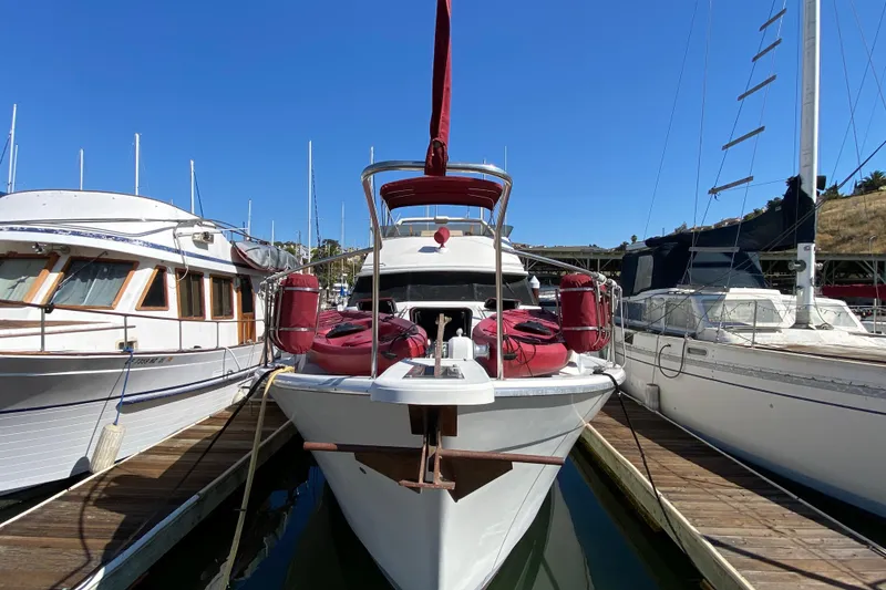 Slide: The Image of 1989 Bayliner 3888 Motoryacht docked between boats under clear blue sky. - 2