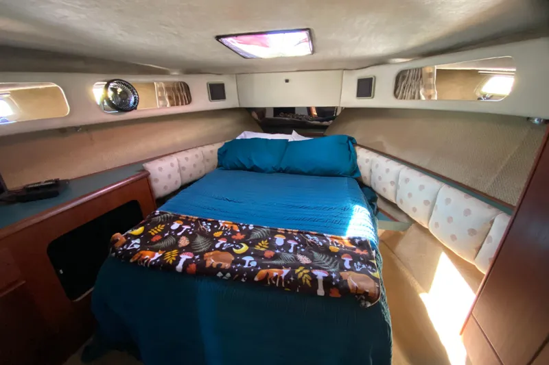 Slide: The Image of Cozy cabin interior of 1989 Bayliner 3888 Motoryacht with bed and colorful blanket. - 21