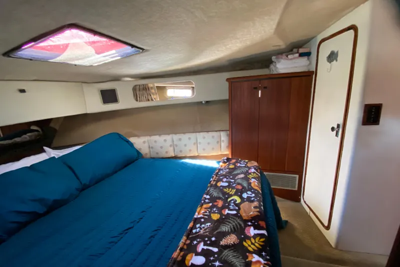 Slide: The Image of Cozy cabin interior of 1989 Bayliner 3888 Motoryacht with bed, wardrobe, and porthole. - 23