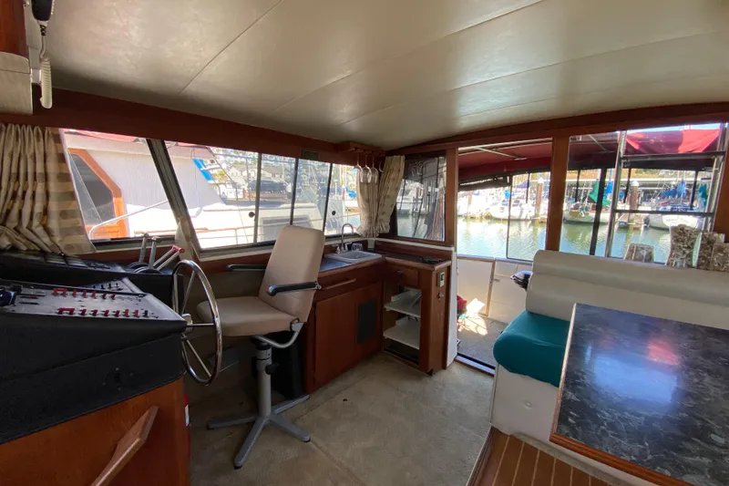 Slide: The Image of 1989 Bayliner 3888 Motoryacht interior with helm, seating, and marina view. - 27