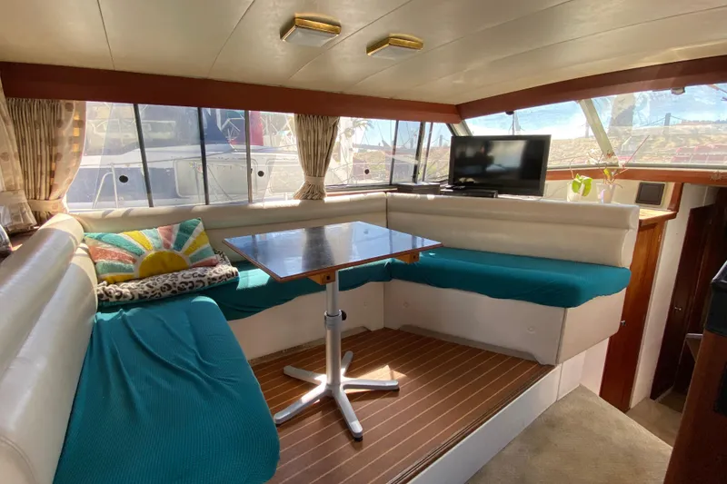 Slide: The Image of 1989 Bayliner 3888 Motoryacht interior with cozy seating, table, and TV. - 28