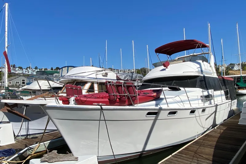 Slide: The Image of 1989 Bayliner 3888 Motoryacht docked at marina under clear blue sky. - 3